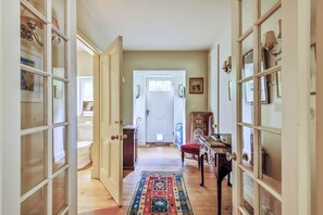 Enter a stylish hallway with a patterned rug and glass-fronted cabinets.