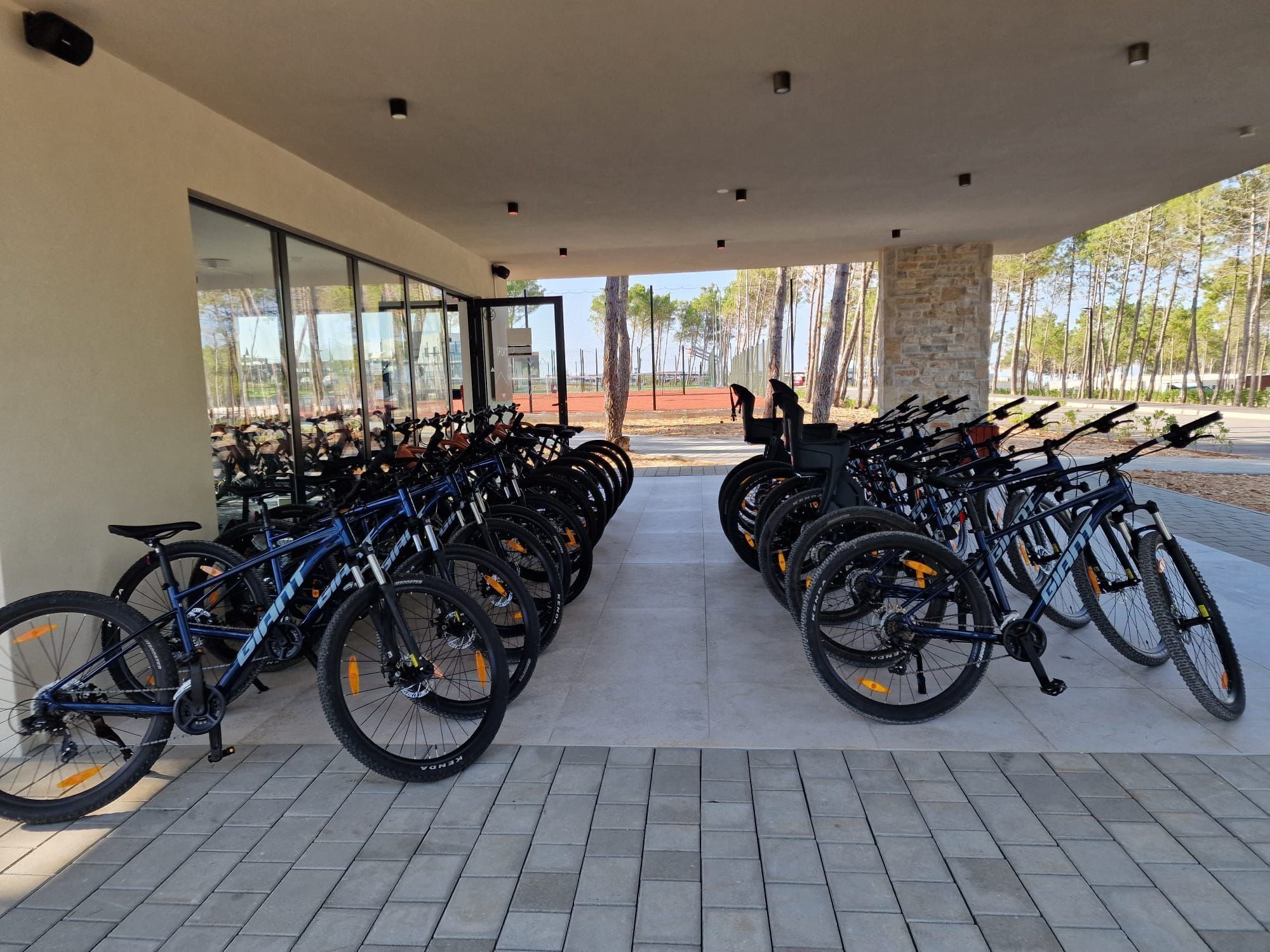 A covered bike parking area with multiple bicycles.