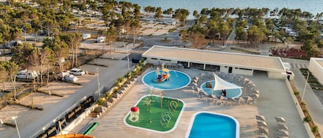 Un resort con piscina, toboganes acuáticos y vistas al mar.