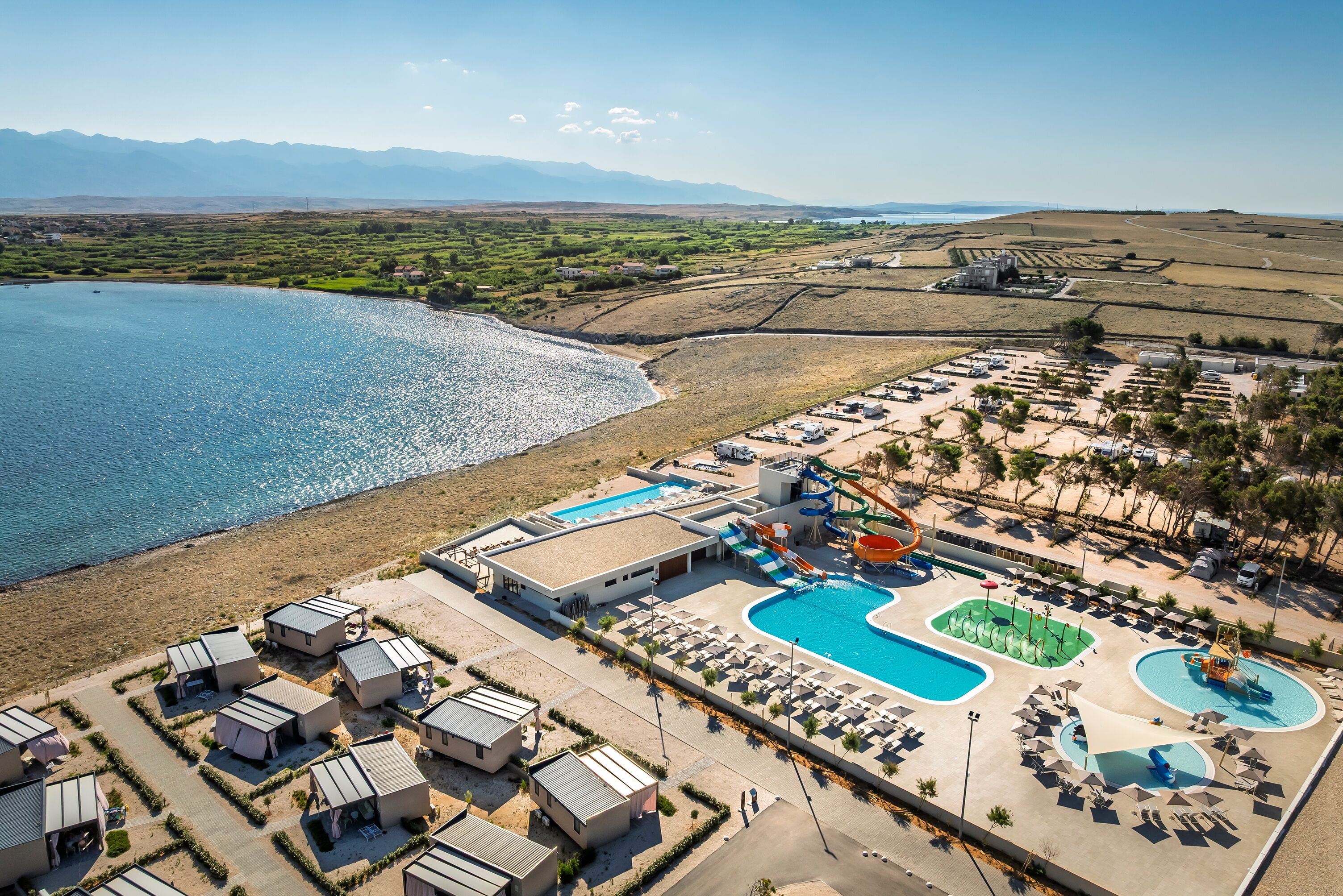 Ein Resort mit mehreren Swimmingpools, einer Wasserrutsche und Unterkünften direkt am Strand.