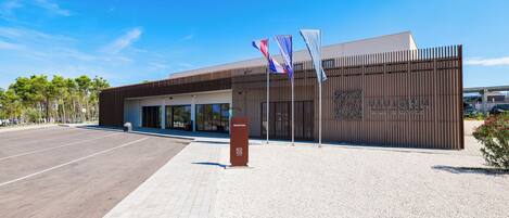 A modern building with a reception desk, flags, and a sign that reads "Avalona Home by Nature".