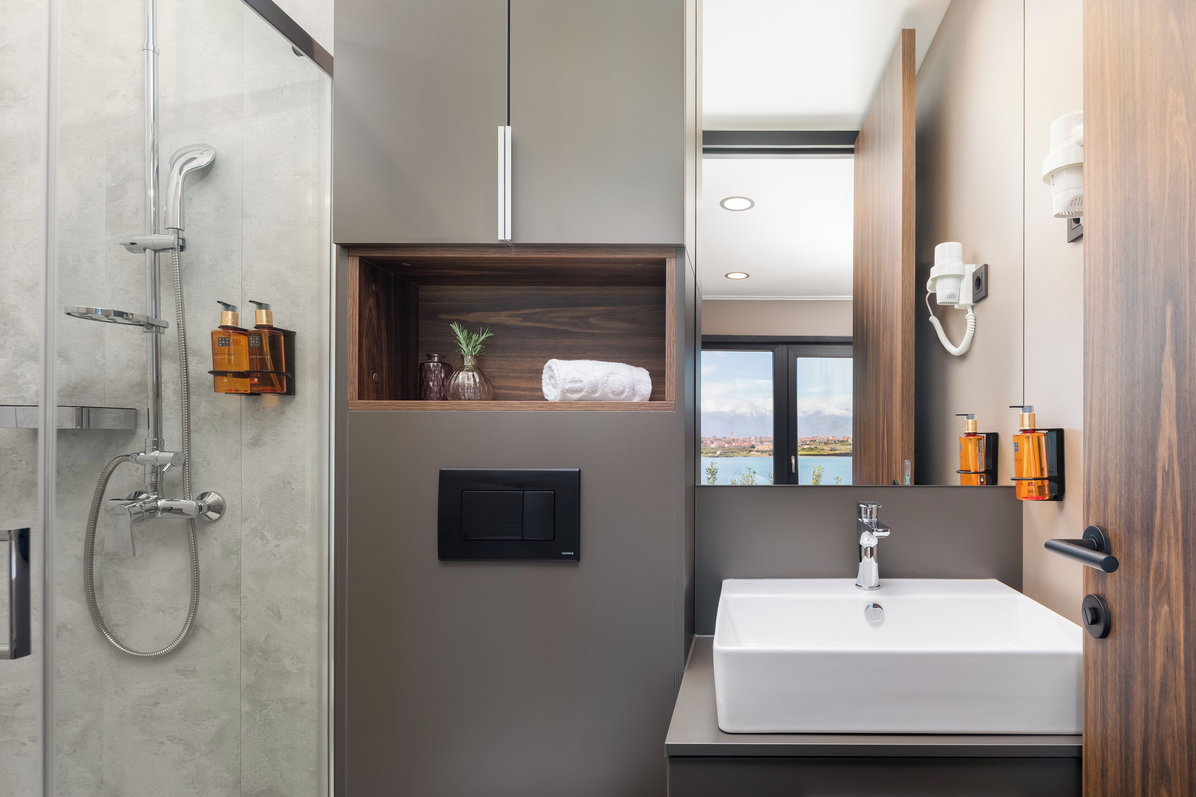 Ein modernes Badezimmer mit Dusche, Waschbecken und Spiegel.