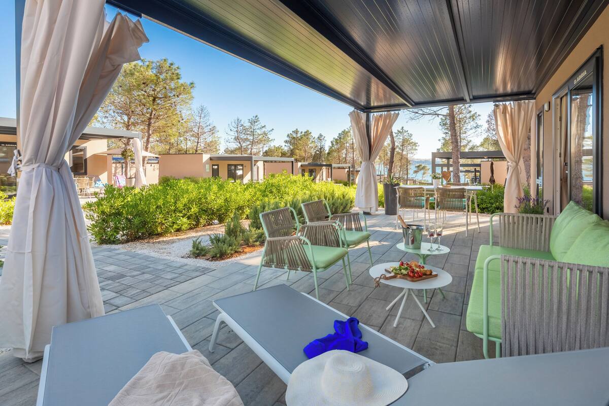 Ein möblierter Patio-Bereich mit Liegestuhl, Sofa und Esstisch.