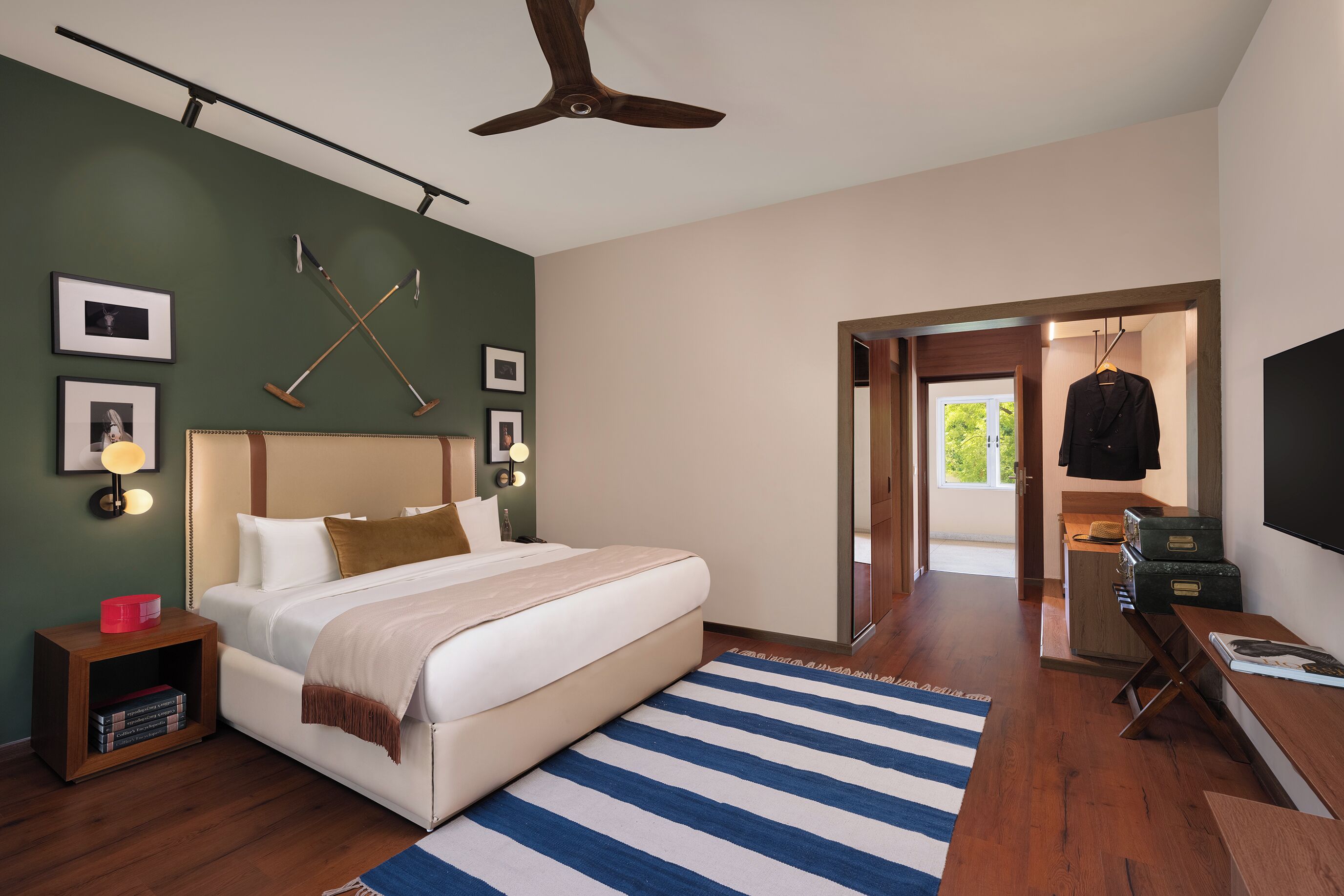 A modern bedroom with a large bed, wooden nightstands, a ceiling fan, and a view of the outdoors.