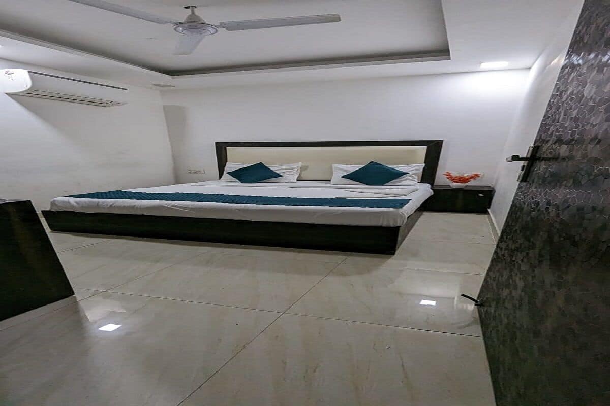 Un dormitorio con cama, ventilador de techo, aire acondicionado y piso de baldosas.