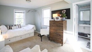 Une chambre à coucher avec un lit, une commode, une chaise, un bureau et une fenêtre.