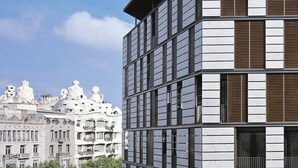 Um edifício moderno com fachada em grade e janelas horizontais.