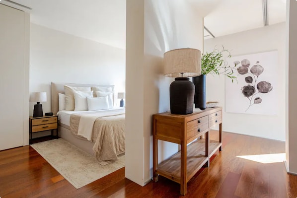 A bedroom with a bed, bedside tables, a lamp, and a painting on the wall. - Best Location Apartment, in the Most Luxurious Street in Barcelona (Barcelona)