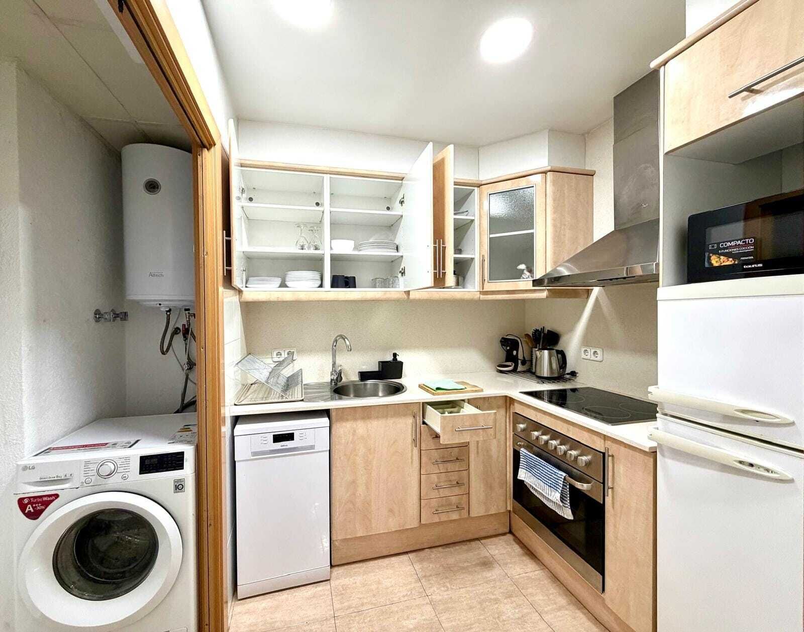 Cocina compacta con lavadora, lavavajillas y horno integrados.
