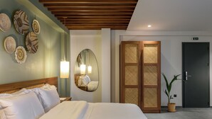 A hotel room with a large bed, a wooden headboard, a wall-mounted mirror, and a potted plant. - Amyntas Seafront Hotel - Adults Only (Sithonia)