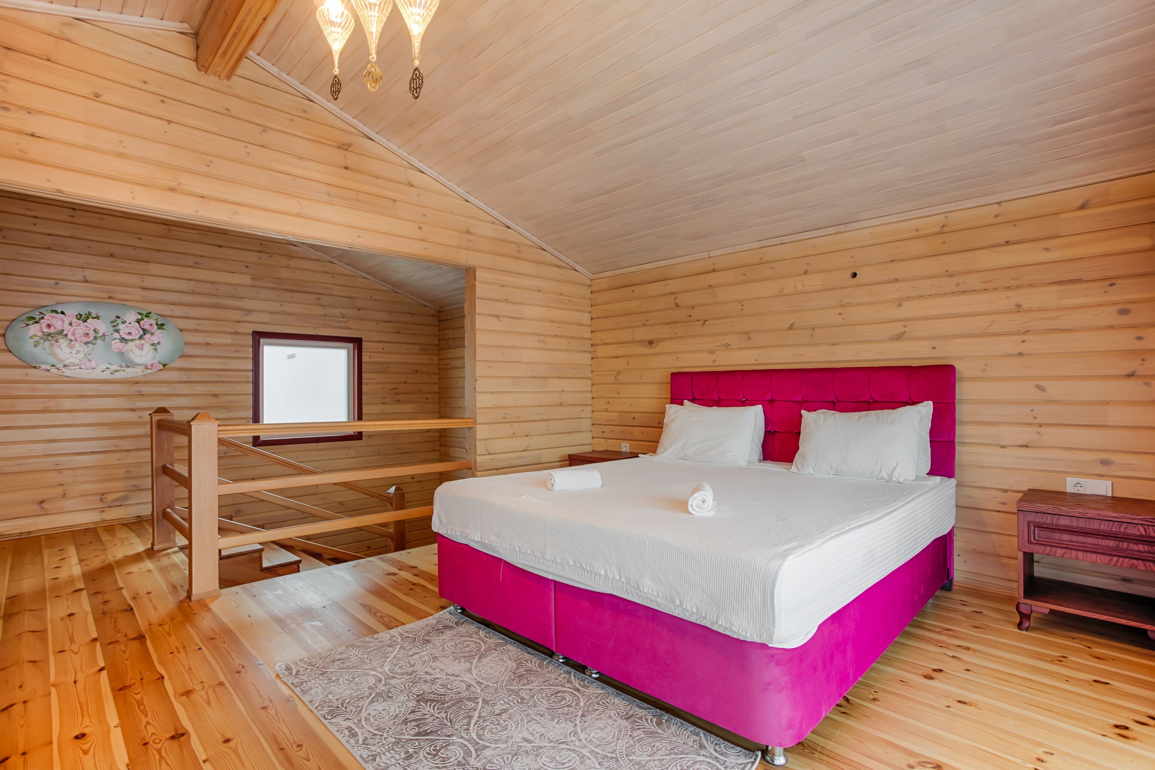 Ein Schlafzimmer einer Holzhütte mit Bett, Fenster und Holzboden.