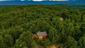 An aerial view of a lodge surrounded by dense forest, with a clear view of the surrounding mountains. - Mountain View! Cabin, 6BR, Yard, Firepit, GameRoom (Sevierville)