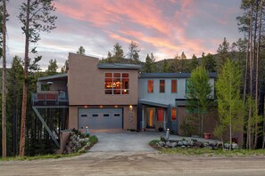 A modern two-story house with a garage, a deck, and a driveway leading to the entrance. - Modern 3Br + Den Home in Breck!- Moonstone Modern (Breckenridge)