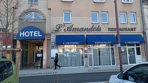 Een hotel met een blauw dakzeil en een bord waarop 'HOTEL' staat.