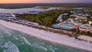 Vista aerea di una zona costiera con un grande resort dotato di numerosi edifici, una piscina e una spiaggia.