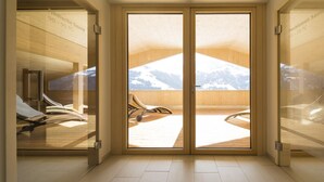 A spa room with a sliding glass door leading to a deck with a mountain view. - Spa-Hotel DAS SCHÄFER (Fontanella)