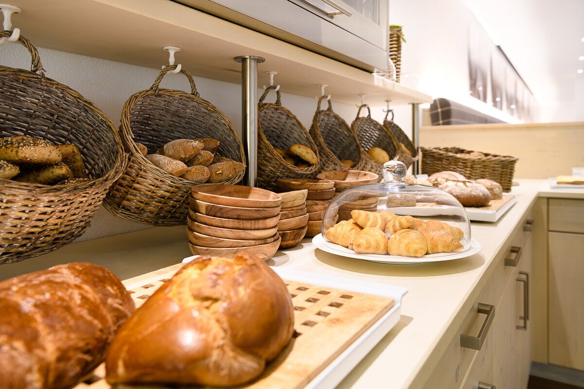A bakery display with various breads and pastries.