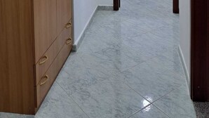 Un couloir avec une armoire en bois, un bureau avec une chaise et une porte donnant sur une autre pièce.