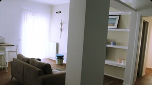 Una sala de estar con un sofá, una mesa de centro y una estantería.