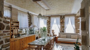 Una cocina amplia con armarios de madera, encimera de mármol e iluminación colgante.