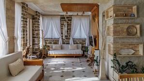Una habitación acogedora con pared de piedra, cama de madera y sofá blanco.
