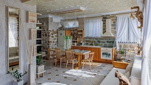 Amplia sala de estar con pared de piedra, muebles de madera y un gran ventanal.