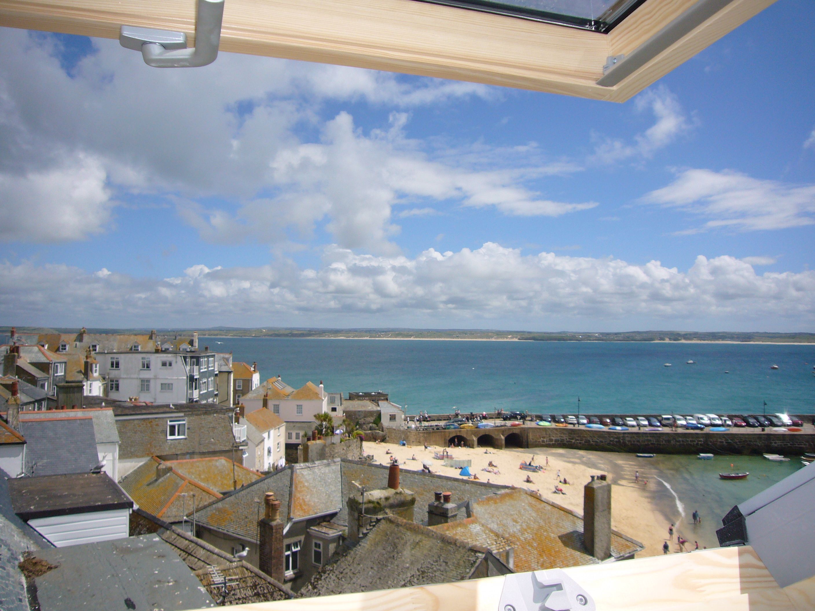 A coastal town with buildings, a beach, and the sea.