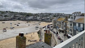 Eine Küstenstadt mit Sandstrand, Booten und Gebäuden entlang der Uferlinie.