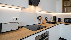Une cuisine moderne équipée d’un grille-pain, d’une machine à café, d’un four à micro-ondes et d’un lave-vaisselle.