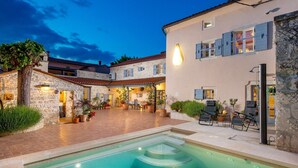 A courtyard with a swimming pool, stone buildings, and outdoor seating. - Rustic Villa Folirantica with pool (Foli)