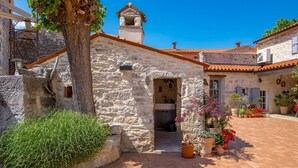 A stone building with a bell tower, a small entrance, and potted plants. - Rustic Villa Folirantica with pool (Foli)