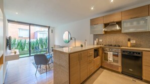 Eine moderne Küche mit Holzausstattung, Edelstahlgeräten und einem großen Fenster mit Blick auf einen Garten.