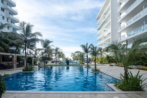 Una piscina rodeada de palmeras y edificios modernos.