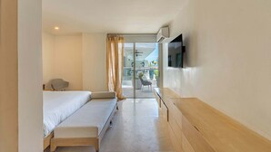 A hotel room with a bed, a desk, a chair, a TV, and a balcony with outdoor seating. - w* | Luxury 4BR w/ Private Pool in Morros Epic (Cartagena de Indias)