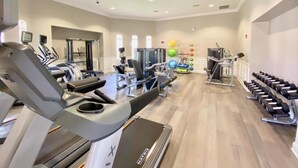 Un gimnasio con cintas de correr, máquinas de pesas y mancuernas.
