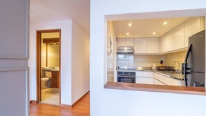 A modern kitchen with stainless steel appliances and white cabinetry. - w* | Industrial 1BR In Cabrera (Bogotá)