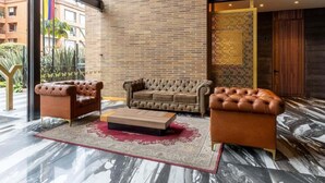 Un salon moderne avec un mur en briques, une grande fenêtre et une vue sur l’extérieur.