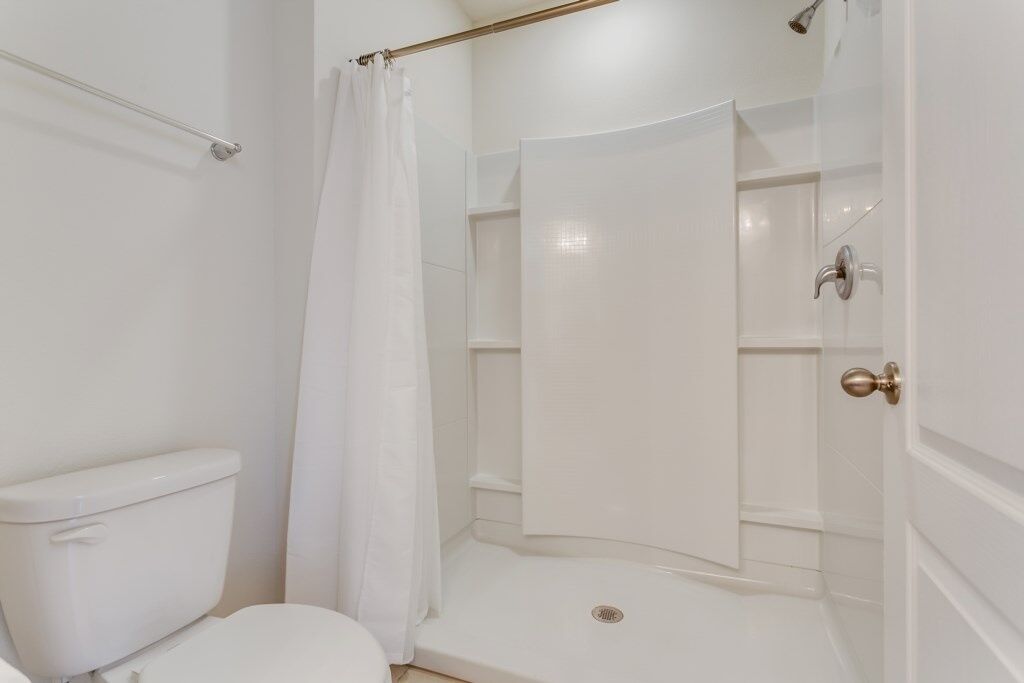 Ein Badezimmer mit Toilette, einer Dusche mit Glastür und einem weißen Waschbecken.
