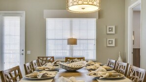 A dining room with a large wooden table set for six, surrounded by wooden chairs. - Penthouse Utopia 3 Bedroom Condo by RedAwning (Orlando)