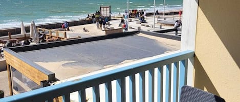 Ein Balkon mit Blick auf Strand und Meer.