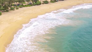 Ein Strand mit klarem türkisblauem Wasser und einem sandigen Ufer.