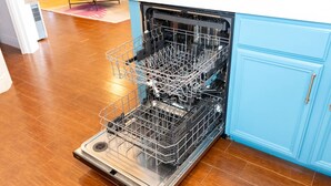 An open dishwasher in a kitchen with wooden flooring and light blue cabinets. - Sun Dancer #11 2 Bedroom Home by RedAwning (South Padre Island)