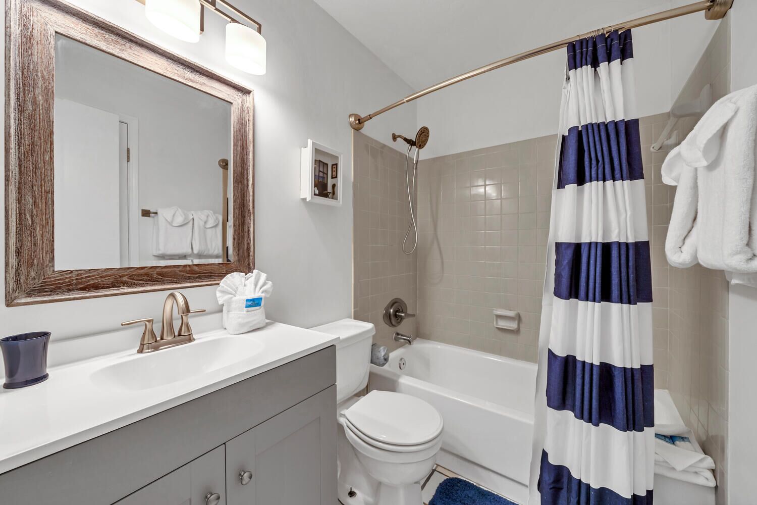 Een badkamer met een witte wastafel, toilet, bad en douchegordijn.