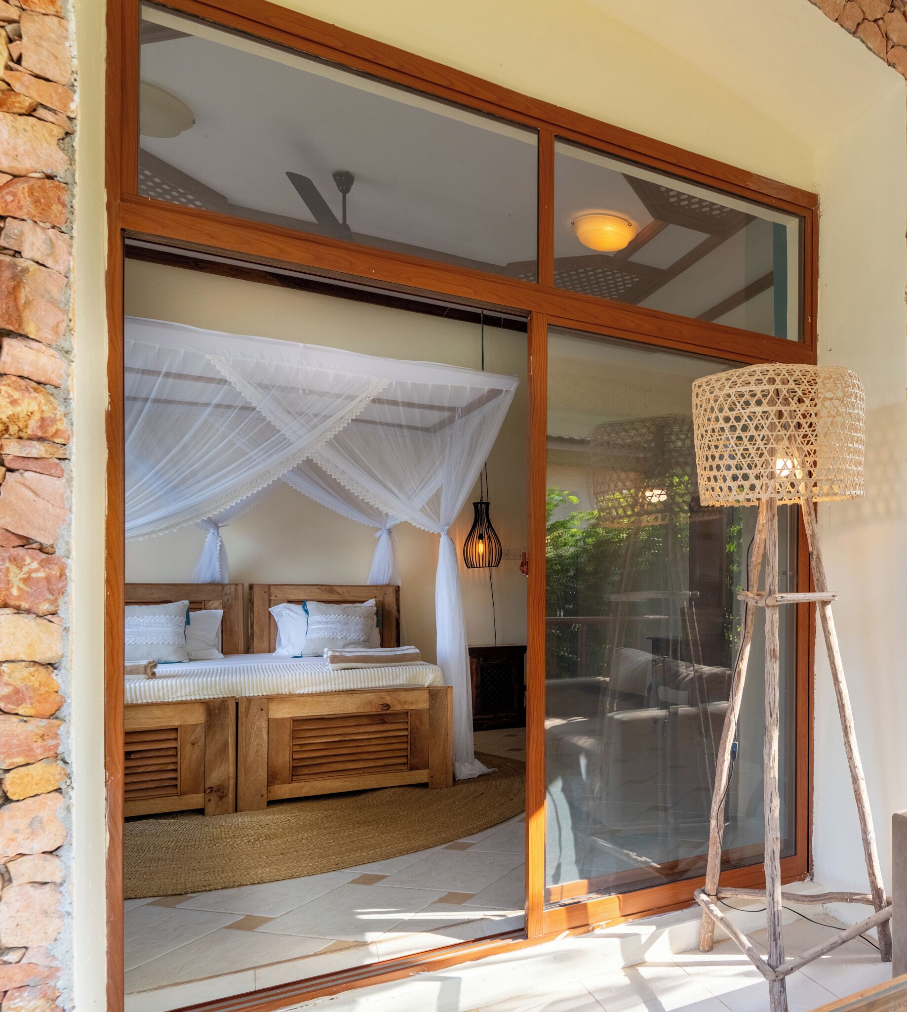 A bedroom with a wooden bed, white bedding, a canopy, and a nightstand.
