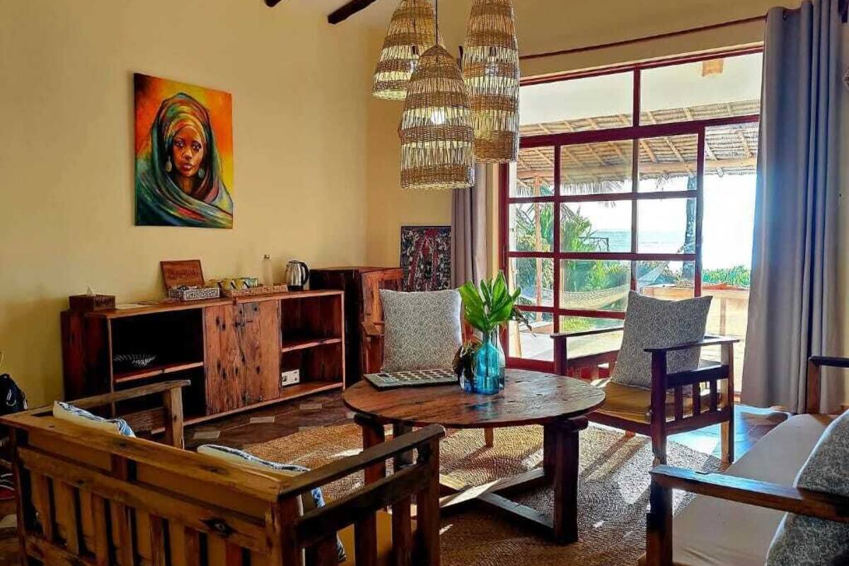 A cozy living room with a wooden table, chairs, a TV, and a large window with a view.