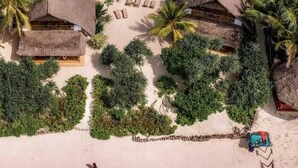 A resort with thatched-roof buildings, a central swimming pool, and palm trees. - Marafiki Beach Hotel & Spa (Matemwe)