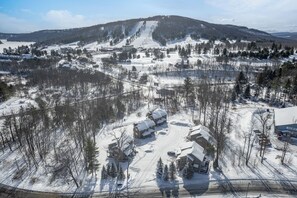 Een skigebied bedekt met sneeuw, met gebouwen, skiliften en een berg op de achtergrond.