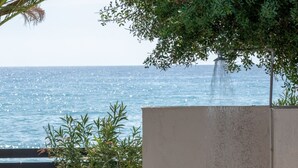 A concrete structure with a door, a small tree, and a view of the sea. - Atalanti Seaside Junior Suites (Viannos)