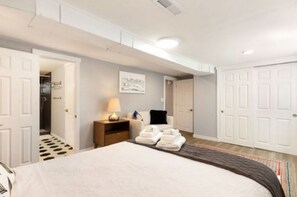 Relax in a stylish room with a large bed, bedside table, and cozy seating area.