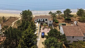 A coastal property with a paved driveway, a parked car, and a view of the beach. - Beach House with 180 degree sea views, 6 Bed, 4 Baths, sleeps 10-12 (La Tranche Sur Mer)
